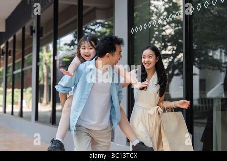 Un'esperienza di shopping in famiglia con genitori e bambini che trascorrono una giornata in città Foto Stock