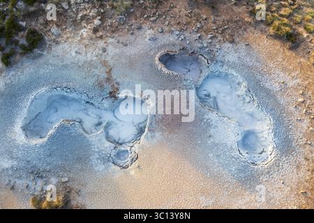 Vista aerea delle piscine geotermali con acque azzurre lattiginose annidate nel paesaggio ocra e grigio, creando una scena surreale e ultraterrena, Selfoss, Sveitarfélagið Árborg, Islanda. Foto Stock