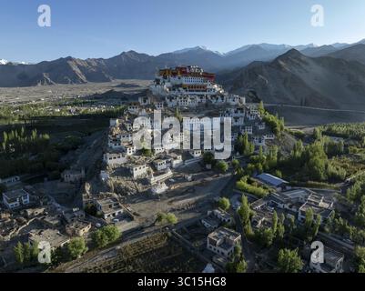 Vista aerea del monastero di Thiksey, arroccato sulla cima di una collina, con i suoi edifici bianchi che contrastano con lo sfondo di montagna, Leh, Ladakh, India. Foto Stock