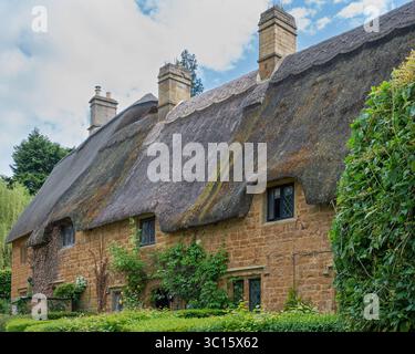 Cottage Ironstone a Great Tew, Oxfordshire, Inghilterra, Regno Unito. Il villaggio fu costruito dal giardiniere John Loudon nel XIX secolo. Foto Stock