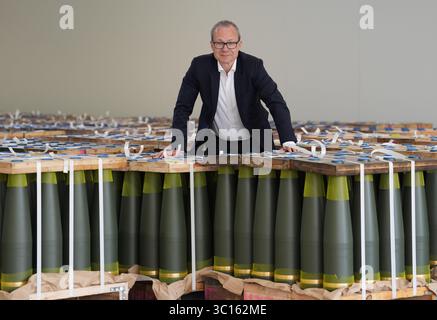 22 luglio 2025, bassa Sassonia, Unterlüß: Matthias Koll, CFO Rheinmetall Weapon and Ammunition, si trova di fronte a proiettili di artiglieria calibro 155 mm nella nuova fabbrica di munizioni LAP della compagnia di armamenti Rheinmetall. Foto: Marcus Brandt/dpa Foto Stock