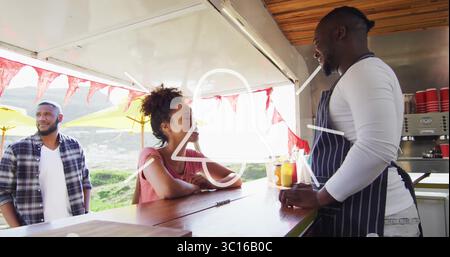 Venditori di camion alimentari e clienti che chiacchierano e ordinavano caffè al banco della collina con tazze di carta rossa Foto Stock
