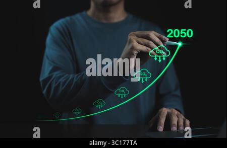 Concetto di riduzione delle emissioni di carbonio. L'uomo d'affari punta a una freccia in aumento con la riduzione del carbonio per ridurre le emissioni di CO2, la riduzione di CO2 in 2050 anni, il piede di carbonio Foto Stock