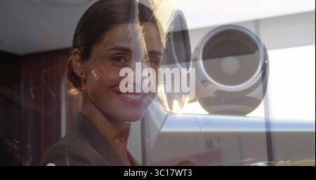 Un blazer grigio professionale che esamina l'obiettivo da parete in legno in ufficio e i riflessi della città Foto Stock