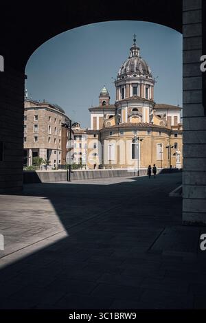 A Roma, vicino a Piazza Augusto Imperatore, la chiesa dei Santi Ambrogio e Carlo al corso è incorniciata da un arco che ne mette in risalto l'architettura. Foto Stock