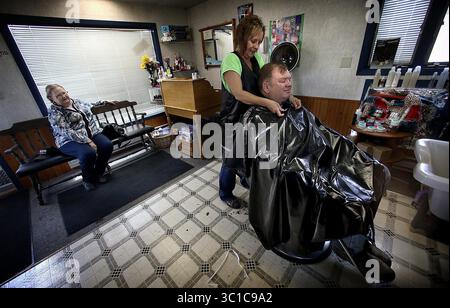 23 ottobre 2013 - Keene, North Dakota, Stati Uniti - PAUL WISNESS si fa tagliare i capelli da LISA THOMPSON mentre sua moglie, SANDI, aspetta il suo turno. Wisness e suo fratello possiedono circa 10.000 acri nel Dakota del Nord che contengono molti pozzi di petrolio, ma non possiedono i diritti minerari su tutti loro. (Immagine di credito: Jim Gehrz/Minneapolis Star Tribune/TNS via cavo ZUMA) Foto Stock