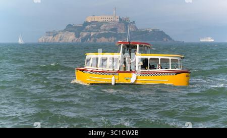 Taxi d'acqua giallo con passeggeri nella baia di San Francisco e nell'isola di Alcatraz Foto Stock