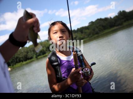 28 luglio 2010 - Bloomington, MN, Stati Uniti - Bloomington, Minn. - 7/28/10 - INFORMAZIONI GENERALI - DEET è stato mostrato nei test sulle acque sotterranee della zona. Abbiamo parlato con la gente di Hyland Lake Park Reserve a Bloomington di come si sentono a riguardo. - IN QUESTA FOTO Natalie Muoa, 8 anni, di St. Paul ha visto suo fratello Vincent prendere un pesce che ha preso dalla sua linea mentre pescava con la famiglia alla Hyland Lake Park Reserve di Bloomington mercoledì. (Immagine di credito: Renee Jones Schneider/Minneapolis Star Tribune/TNS via cavo ZUMA) Foto Stock
