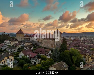 Vista aerea del castello medievale di Annecy e della città con un cielo nuvoloso al tramonto Foto Stock
