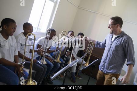 12 agosto 2018 - Durban, Minnesota, SUD AFRICA - il trombone della Minnesota Orchestra Andrew Chappell saluta i membri della KwaZulu Natal Youth Wind Band dopo una sessione di breakout. ...INFORMAZIONI DI BASE: Un gruppo dell'Orchestra del Minnesota visita la KwaZulu Natal Youth Wind Band per un'attività di fidanzamento alla Durban Music School di Durban, in Sudafrica, domenica 12 agosto 2018. (Immagine di credito: Leila Navidi/Minneapolis Star Tribune/TNS via cavo ZUMA) Foto Stock