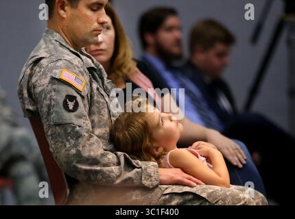 13 giugno 2015 - St. Paul and Anoka, MN, Stati Uniti - cerimonia ufficiale di ritorno della 34th Combat Aviation Brigade's Headquarters Company e 2nd Battalion, 147th Assault Helicopter Battalion da un dispiegamento di un anno a sostegno dell'operazione Enduring Freedom-Kuwait e dell'operazione Inherent Resolve in Iraq sabato 13 giugno, presso l'Anoka College di Anoka, Minnesota. Il gruppo tornò a casa nel maggio del 2015. Qui, il sergente Aaron Jacobsen di Farmington tiene sua figlia Mollie, 4 anni, seduta accanto a sua moglie Jamie durante l'evento. La cerimonia ufficiale del ritorno a casa della 34th Combat Aviation Brigade Headquar Foto Stock