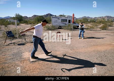 20 gennaio 2017 - Quartzsite, Arizona, USA - Jim Waytashek, contadini in pensione di Pierz Minnesota (a sinistra) lancia ferro di cavallo con Tom Brock di Buffalo New York. Jim e sua moglie Jan, vengono a Quartzite da quasi 20 anni e ora fanno volontariato nell'area di campeggio a lungo termine di LaPosa a sud di Quartzsite. Quartzsite, Arizona, non è altro che una sosta per camion durante i mesi estivi, ma tra ottobre e aprile, la piccola città desertica del 3.500 raggiunge i quaranta milioni di abitanti. Gli uccelli delle nevi, i boondockers e gli abitanti del deserto si radunano nella vicina terra BLM, che costerà solo $ 180 per un 6 mesi Foto Stock