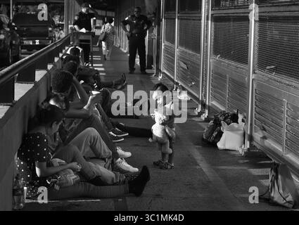 2 luglio 2018 - Matamoros, Messico - Ingrid Perdomo, 18 anni, e suo figlio di 1 anno Jose Luis con altri richiedenti asilo dormono sul ponte Gateway International in attesa di attraversare gli Stati Uniti dal lato del Messico. È venuta con il suo compagno Luis Miguel, 32 anni dall'Honduras, dove hanno fatto il difficile viaggio di 3 mesi. Ha detto di essere fuggito nella paura e piange molto con ansia per il suo passato. La sua ex moglie ha iniziato a frequentare un membro della gang e la gang ha incendiato la sua casa uccidendo i suoi due figli all'interno. Fuggì sulle montagne in cerca di sicurezza, dove incontrò Ingrid e ebbero un altro figlio. Quando sono arrivati, hanno detto di sì Foto Stock