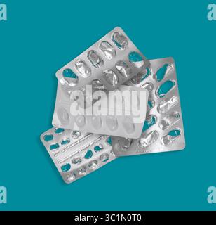 Avvolgitori per pillole vuote. Blister Medicina vuoti. Confezioni di blister per farmaci in argento e bianco su sfondo blu turchese chiaro. Foto Stock