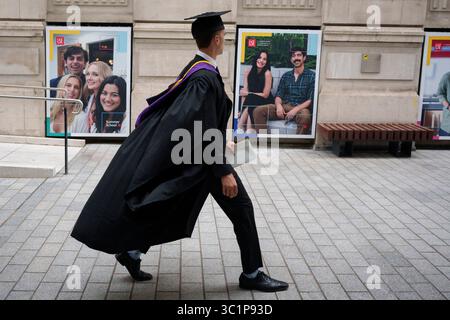 Un laureato che celebra la sua laurea alla London School of Economics (LSE) attraversa il campus universitario, il 22 luglio 2025, a Londra, in Inghilterra. Foto Stock