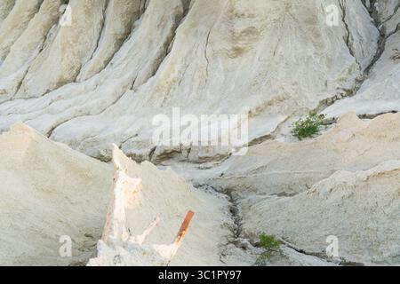 Un ipnotico primo piano di una cava di sabbia bianca, che rivela intricati schemi di erosione, profonde gole e trame geologiche astratte della terra. Foto Stock