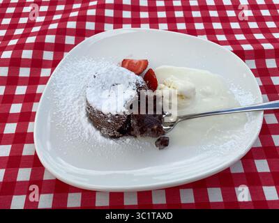 Dessert francese fondente al cioccolato con fragole e gelato Foto Stock
