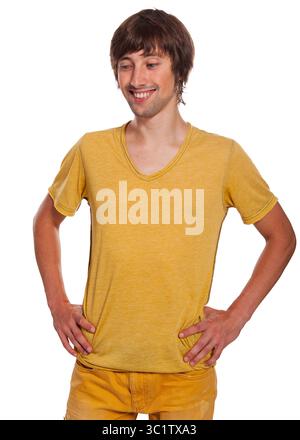 Il giovane sorride con le mani sui fianchi, sfoggiando un vestito giallo brillante. Foto Stock
