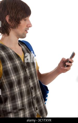 Un uomo con un gilet elegante si impegna con il suo smartphone, perso nel pensiero. Foto Stock