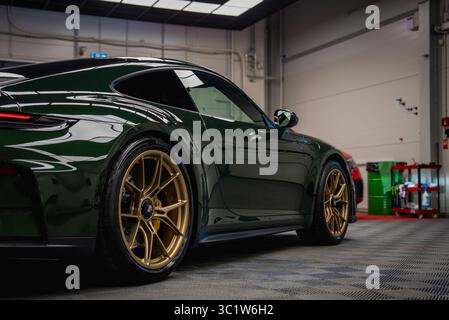 Porsche 911 GT3 Touring verde scuro in un garage ben illuminato Foto Stock