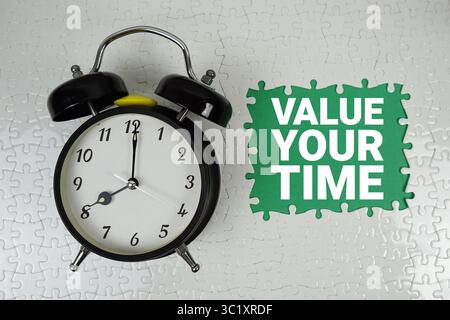 Valuta il testo dell'ora con la sveglia su sfondo verde Foto Stock