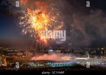 La vista di fuochi d'artificio illuminano il cielo notturno su un vasto paesaggio urbano, una sinfonia di luci e suoni sopra Mosca, Mosca, Russia. Foto Stock