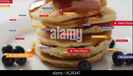 Pila di cinque pancake con sciroppo gocciolante sul piano portapaziente, con mirtilli e etichette di notifica fluttuanti Foto Stock