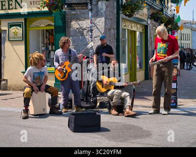 Galway, Irlanda - 13 giugno 2025: Un vivace gruppo di musicisti intrattiene i passanti a Galway, Irlanda, in una giornata luminosa e soleggiata. Foto Stock