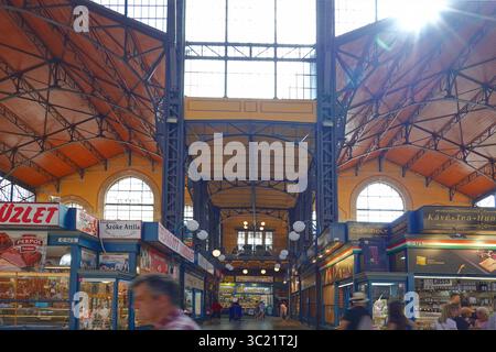 Il grande mercato coperto o il mercato centrale, Budapest, Ungheria - mercato coperto a Budapest, Ungheria - mostra gli acquirenti e il sole scoppia attraverso la finestra Foto Stock
