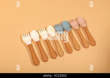 Set di cucchiai e forchette in silicone colorato con manici in legno Foto Stock