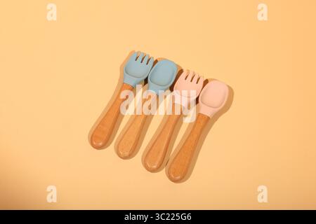 Set di cucchiai e forchette in silicone colorato con manici in legno Foto Stock