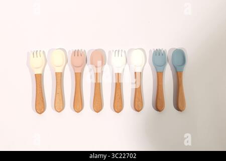 Set di cucchiai e forchette in silicone colorato con manici in legno Foto Stock