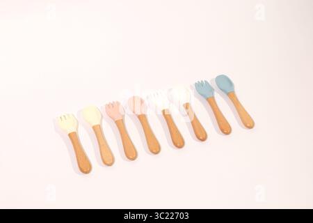 Set di cucchiai e forchette in silicone colorato con manici in legno Foto Stock