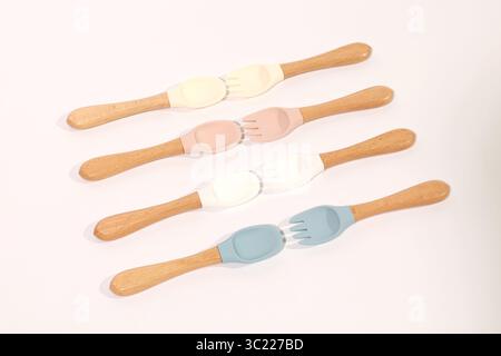 Set di cucchiai e forchette in silicone colorato con manici in legno Foto Stock