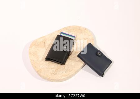 Collezione di portafogli in pelle con carte di credito su sfondo bianco, beige e marmo Foto Stock