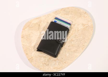 Collezione di portafogli in pelle con carte di credito su sfondo bianco, beige e marmo Foto Stock