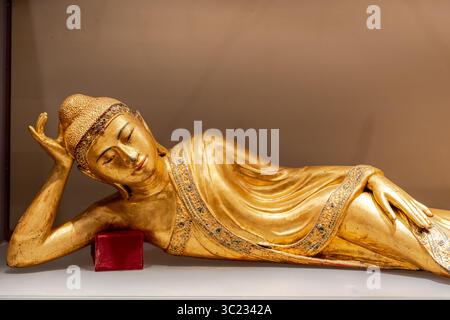 Statua dorata del giovane Buddha che si posa in posa Foto Stock