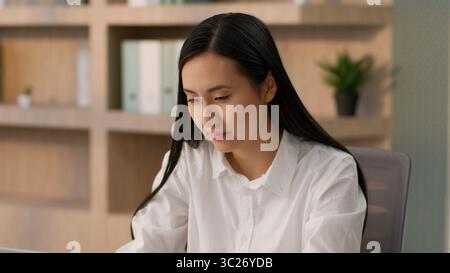 Concentrata donna d'affari asiatica coreana donna d'affari professionale leader capo giapponese donna d'affari cinese lavoratrice d'ufficio che lavora online Foto Stock