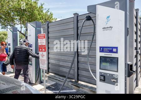 North Miami Beach, Florida, grandi magazzini Walmart, grande scatola, esterno, adulto adulto, ispanico senior collegato a un'auto elettrica presso Electrify Foto Stock