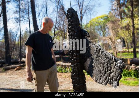 22 aprile 2019 - Paradise, CA, USA - Stewart Nugent si trova accanto al cartello dell'indirizzo danneggiato dall'incendio sulla sua proprietà lunedì 22 aprile 2019 a Paradise, California. Stewart salvò la sua casa e quella dei suoi vicini, Abigail Lopez e Donovan Frary, durante l'incendio del campo. (Immagine di credito: © TNS via cavo ZUMA) Foto Stock