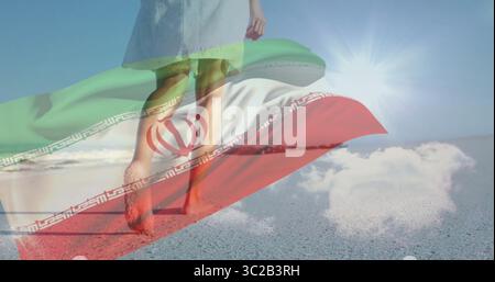 Donna che cammina con un abito bianco a piedi nudi lungo la spiaggia, con una sovrapposizione traslucida bandiera iraniana Foto Stock