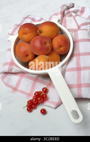 Albicocche in un colino e ribes rossi Foto Stock