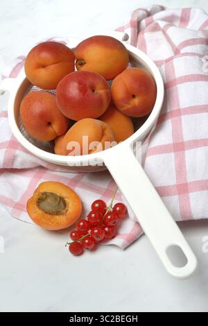 Albicocche in un colino e ribes rossi Foto Stock