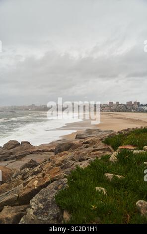 Un ambiente costiero sereno e tranquillo caratterizzato da una costa rocciosa con dolci onde oceaniche che si infrangono dolcemente Foto Stock