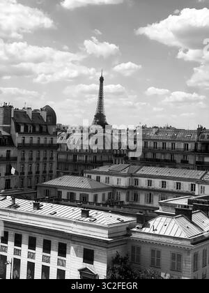 Parigi Francia 9 maggio 2025 Fotografia in bianco e nero che cattura l'iconica Torre Eiffel tra i classici tetti parigini. Nuvole spettacolari migliorano il tempo Foto Stock
