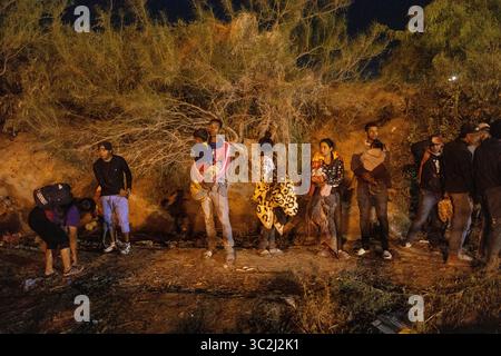 I migranti si radunano vicino al fitto fogliame al confine di Ciudad Juarez. Foto Stock