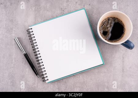 Vista dall'alto del blocco note vuoto e della tazza di caffè Foto Stock