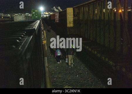 I migranti navigano sui treni parcheggiati al confine di Ciudad Juarez. Foto Stock