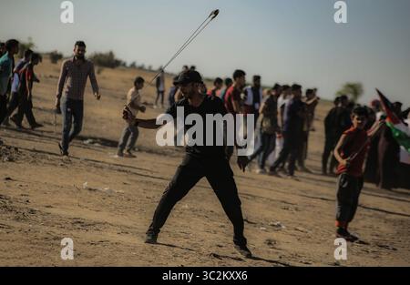 5 luglio 2019 - Gaza, Khan Younis, Palestina - un dimostrante palestinese utilizza un slingshot per scagliare pietre contro le forze israeliane nel corso di una manifestazione per chiedere la fine dell'assedio alla Striscia di Gaza nel sud della striscia di Gaza. (Credito Immagine: © Yousef Masoud/SOPA immagini via ZUMA filo) Foto Stock
