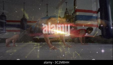 I partner di allenamento push-up si allenano nella palestra di arti marziali con tappetini imbottiti e rivestimento luminoso. Fitness, allenamento, tecnologia, forza, salute, collaborazione Foto Stock
